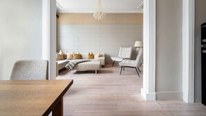 Una sala moderna con sofá, sillones y una mesa de comedor.
