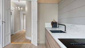 A modern kitchen with a built-in stove, a sink, and a wooden countertop. - Experience the luxury lifestyle 100m from Bryggen! (Bergenhus)