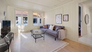 A spacious living room with a sofa, coffee table, and TV.