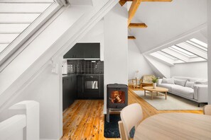 Ein modernes Loft mit Küche, Kamin und Wohnbereich mit Sofa und Couchtisch.