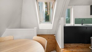 A modern loft bedroom with a skylight, a wooden floor, and a view of the outside. - Bryggen  Historical Townhouse I Rooftop Views! (Bergenhus)