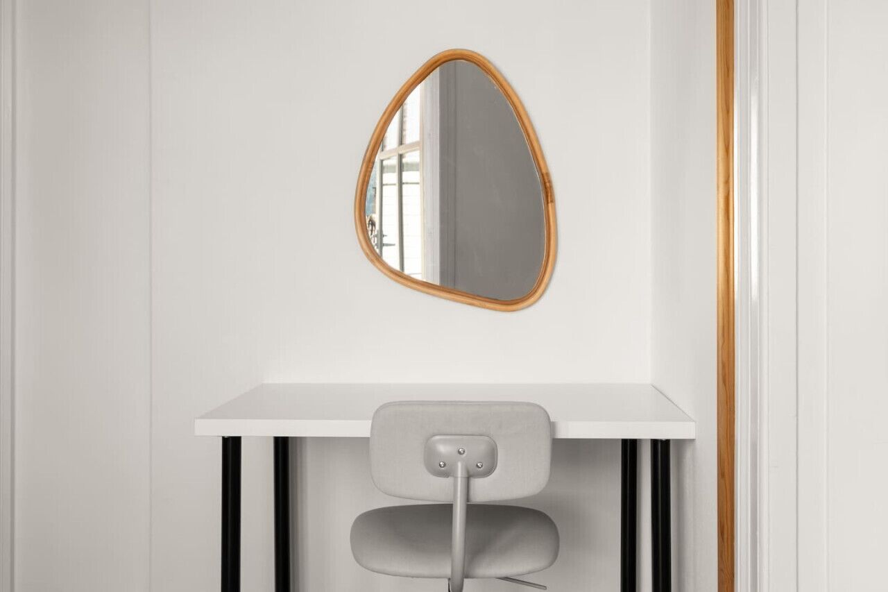 A white desk with a mirror and a chair.