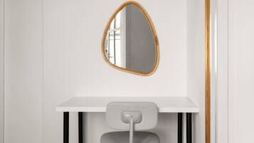 A white desk with a mirror and a chair.