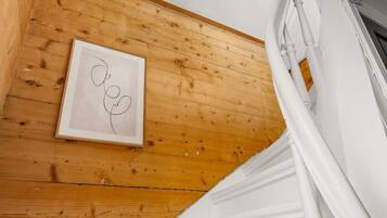 A staircase with a wooden floor and white walls, leading to a higher level.