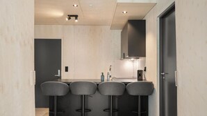 A modern kitchen with a central island, bar stools, and a built-in oven. - The Double Date I  Architectural (Bergenhus)