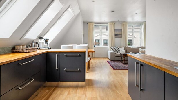 Una cocina moderna con tragaluces, un área de comedor con sofá y vistas a la ciudad.