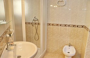 Une salle de bain équipée d’un lavabo, d’un bidet et d’une douche.