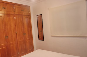 Un dormitorio con un armario grande, un espejo y una cama.