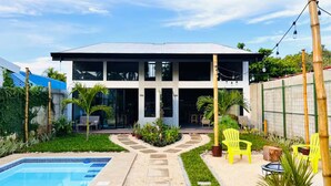 Une maison moderne à deux étages, dotée d’une piscine, d’un espace extérieur aménagé et d’un jardin bien entretenu.