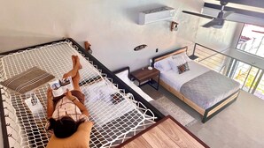 Une chambre avec un lit, un coin lecture et une fenêtre donnant sur un beau paysage.