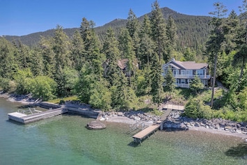 Set among towering trees with 100 feet of private lake frontage, you’ll enjoy direct access to Flathead Lake from your private dock and boat lift (pontoon compatible), making it the ideal base for boating, swimming, or just soaking up the sun.