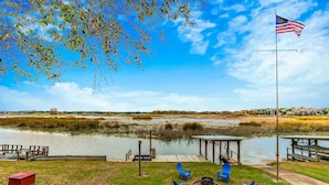 A lakeside deck with outdoor seating and a flagpole. - Lake Side Retreat (Inverness)