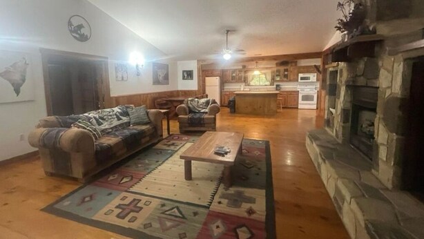 A cozy living room with a sofa, armchairs, a coffee table, and a fireplace.
