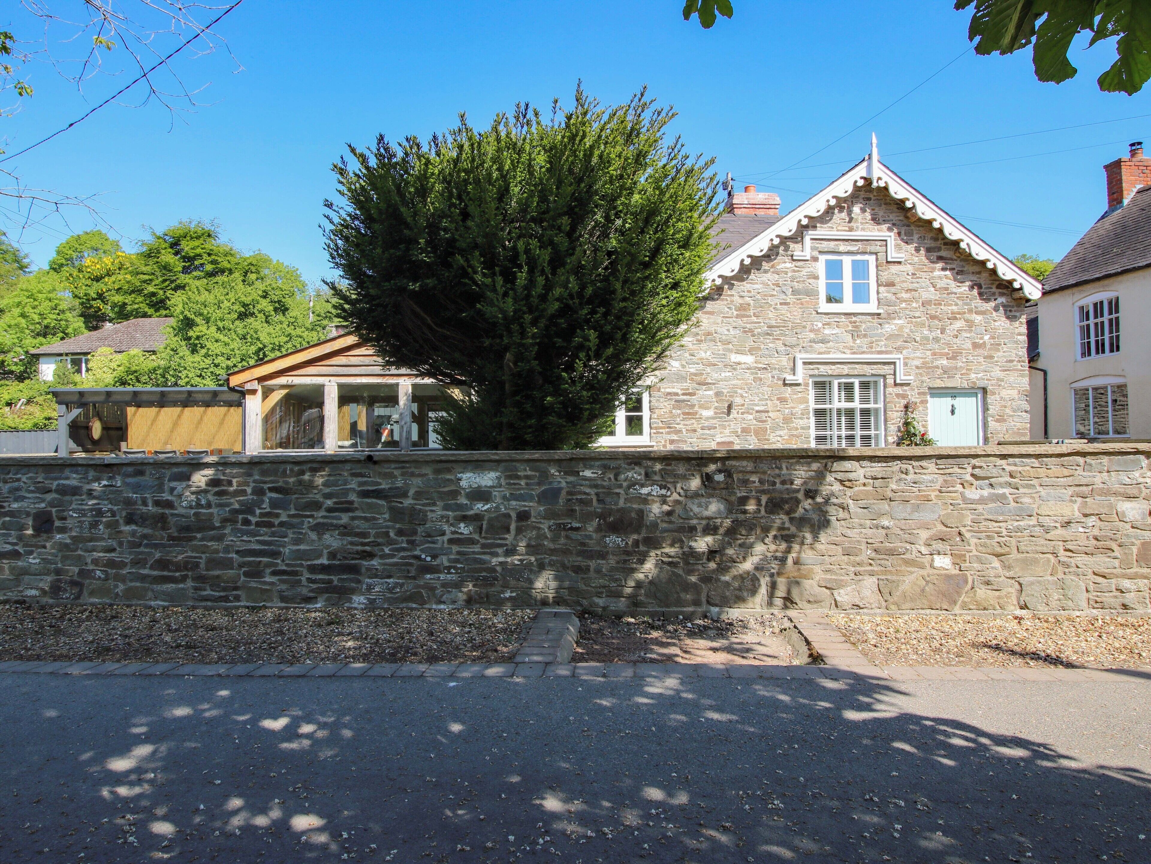 A stone building with a pitched roof and a small porch.
