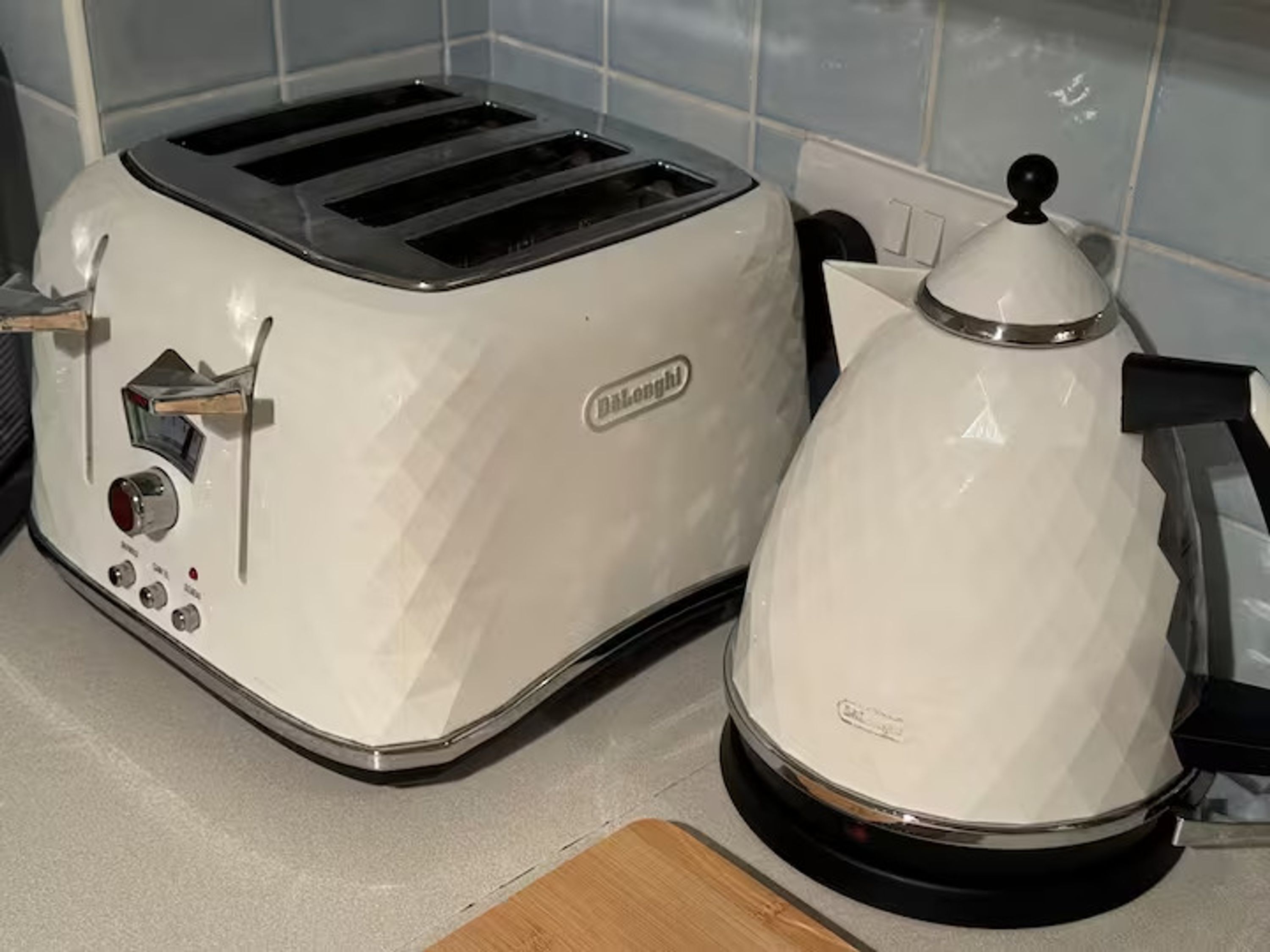 Un tostador blanco y una tetera eléctrica blanca sobre una encimera de cocina.