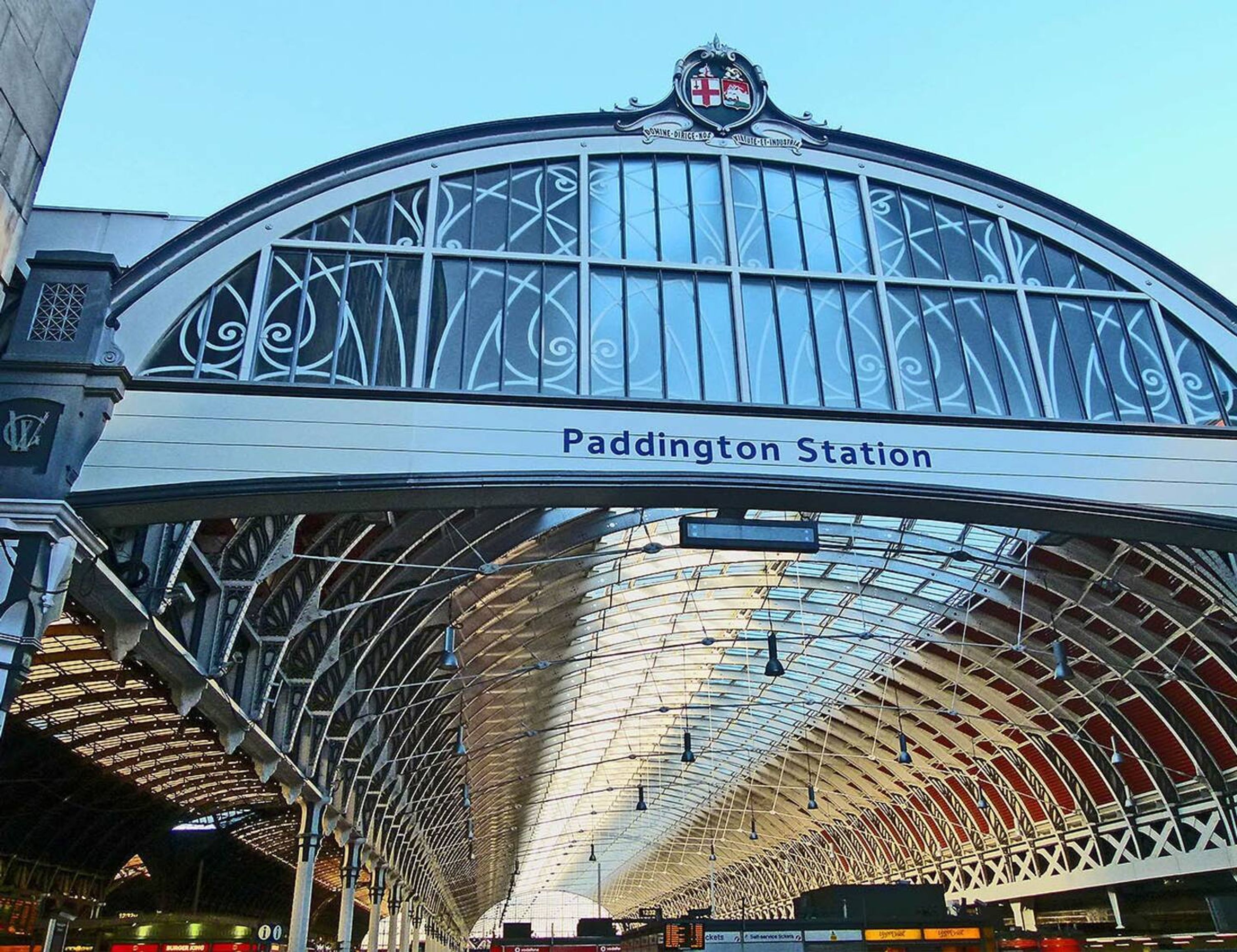 Paddington Station with a distinctive arched roof and a sign indicating its name.
