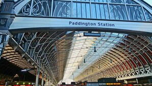 La gare de Paddington, reconnaissable à son toit en arc distinctif et à une enseigne indiquant son nom.