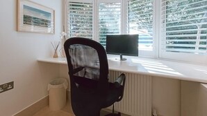 Ein moderner Arbeitsplatz mit Schreibtisch, Computer und Stuhl.
