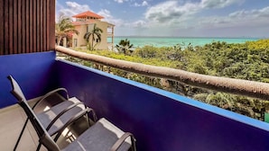 Un balcon avec vue sur une plage et un immeuble.
