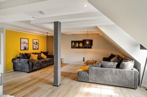 A modern living room with two sofas, a coffee table, and artwork on the walls. - Apartment 'Domschatz' with Wi-Fi and Air Conditioning (Goslar)