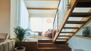 Una escalera con vigas de madera y una planta en maceta al frente.