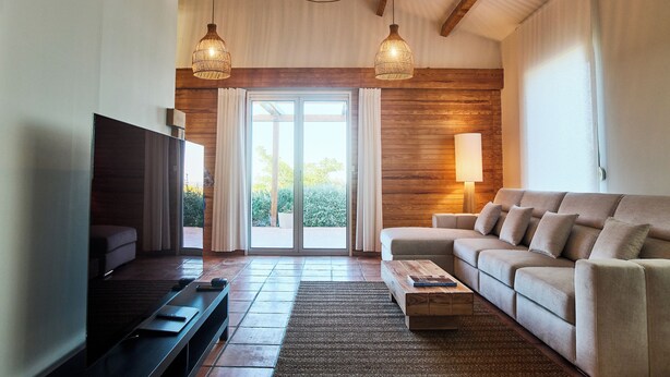 Una sala de estar con televisor, sofá y detalles de madera.