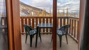 A balcony with a table and chairs, offering a view of a snowy mountain landscape. - 40m from ski slopes, 1st floor, fitness, swimming pool, sauna, balcony, tv, ski locker, 30-38m² (Les Orres)