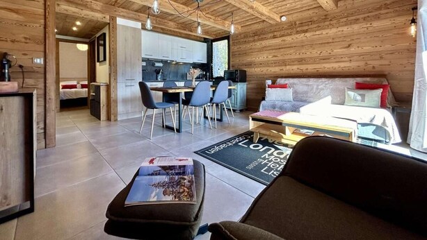 A cozy cabin interior with a wooden ceiling, a dining area, a living room with a sofa, and a kitchen. - 2nd floor, view panoramic, balcony, tv, 45m², Serre Chevalier (Briançon)