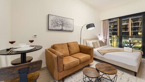A modern hotel room with a sofa, a dining table, and a bed. - FIRST CLASS | Studio | Urban Elegance (Dubai)