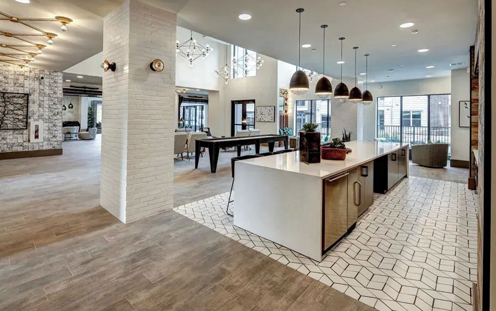 A spacious kitchen with a central island, pendant lighting, and a view of the dining area.