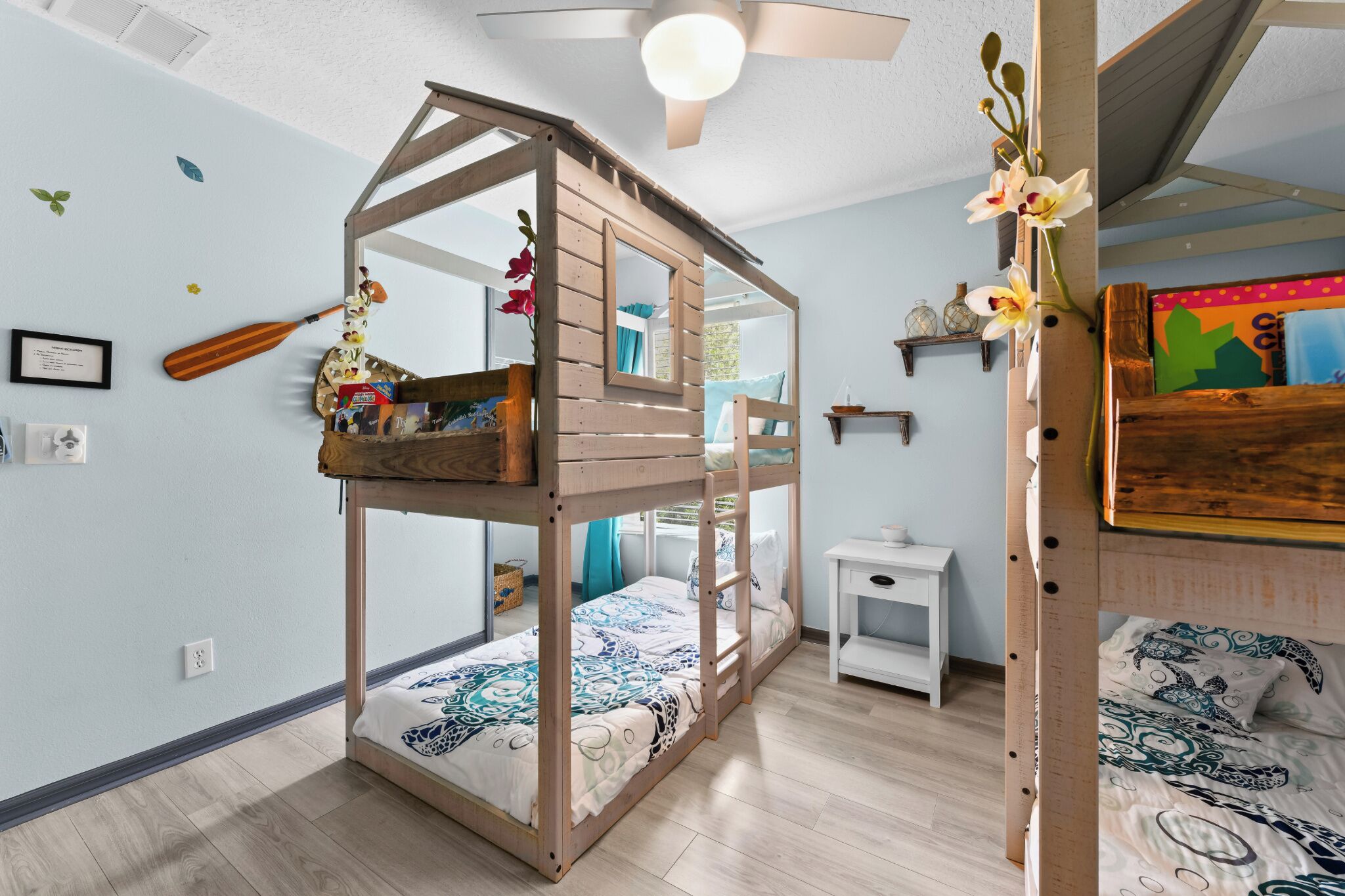 A bunk bed with a wooden ladder and a small table beside it.