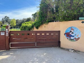 Une entrée sécurisée avec une fresque murale en mosaïque, un comptoir d’accueil et un espace de stationnement.