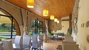 Un comedor rústico con techo de madera, ventanas grandes y vistas al exterior.