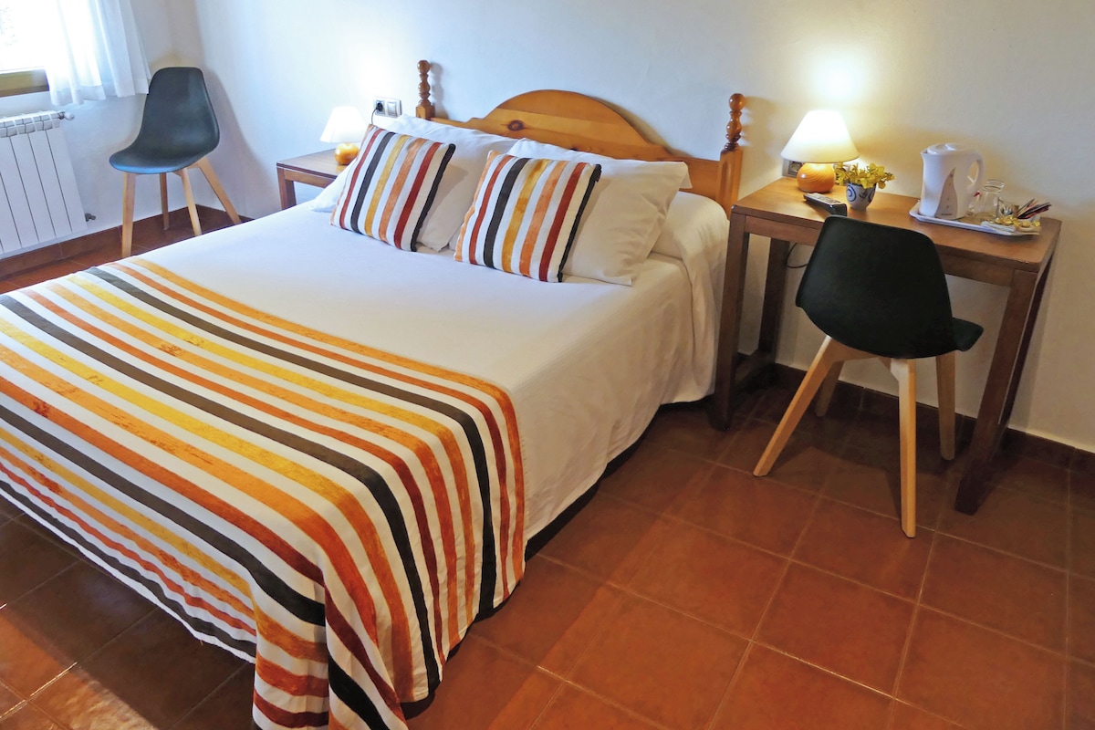 Ein Hotelzimmer mit einem Bett, einem Schreibtisch, einem Stuhl und einer Heizung.