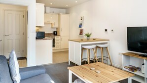 Un apartamento moderno con sala de estar, kitchenette y comedor.