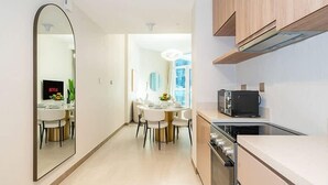 Een moderne keuken met een magnetron, oven en een eethoek met een ronde tafel en stoelen.