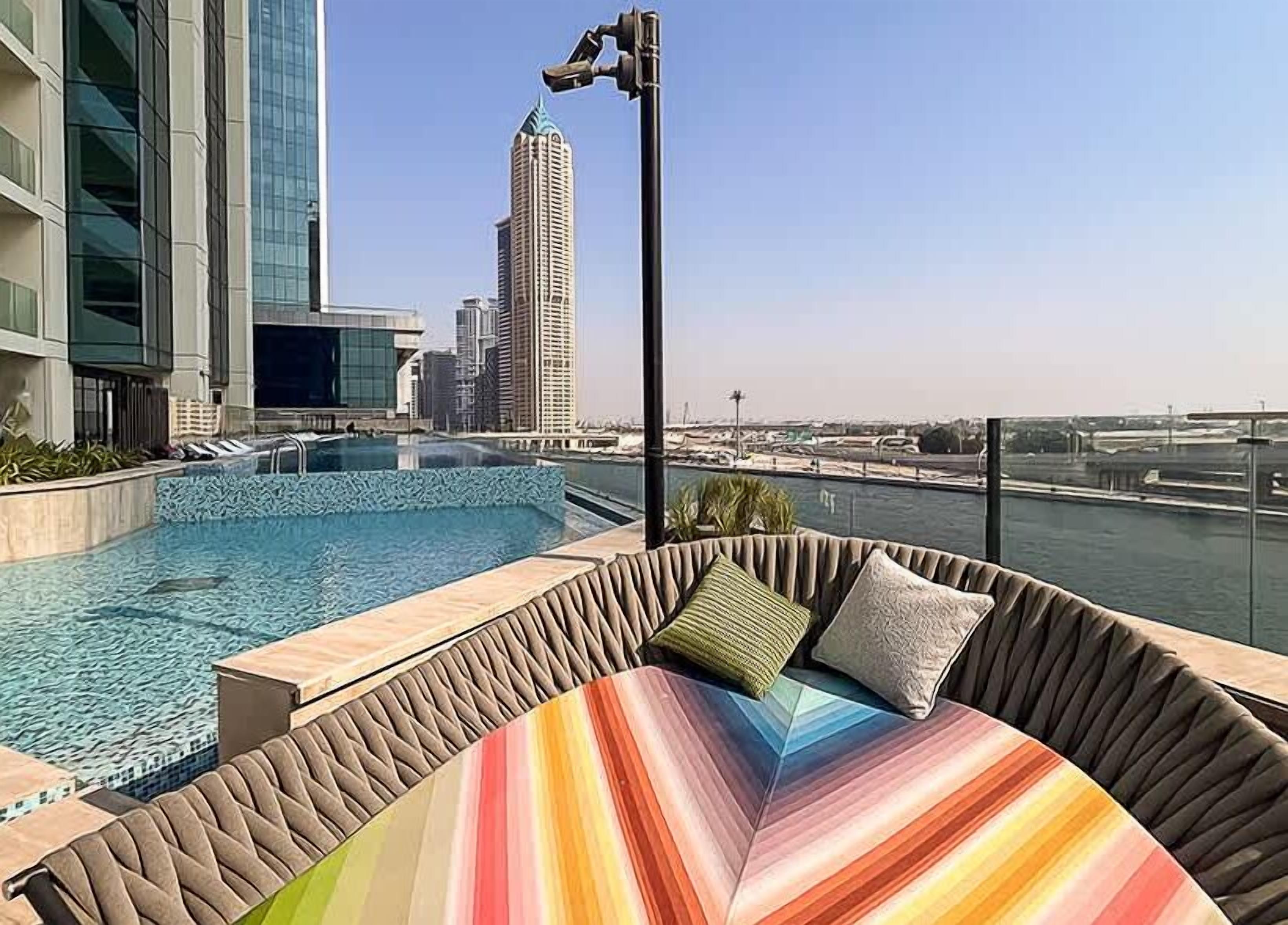Piscina no terraço com vista para o horizonte urbano, incluindo um edifício alto.