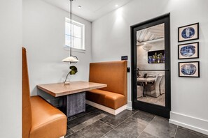 A modern hotel room with a seating area, a small table, and a door leading to a balcony with city views. - Beach Bliss: Modern 3 Bed Oasis Mins from Shore (Apollo Beach)