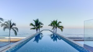 A swimming pool with a clear view of the beach and ocean.