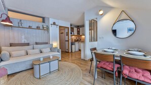 Un salon moderne comprenant un canapé, une table basse et un coin repas avec des chaises et une table.