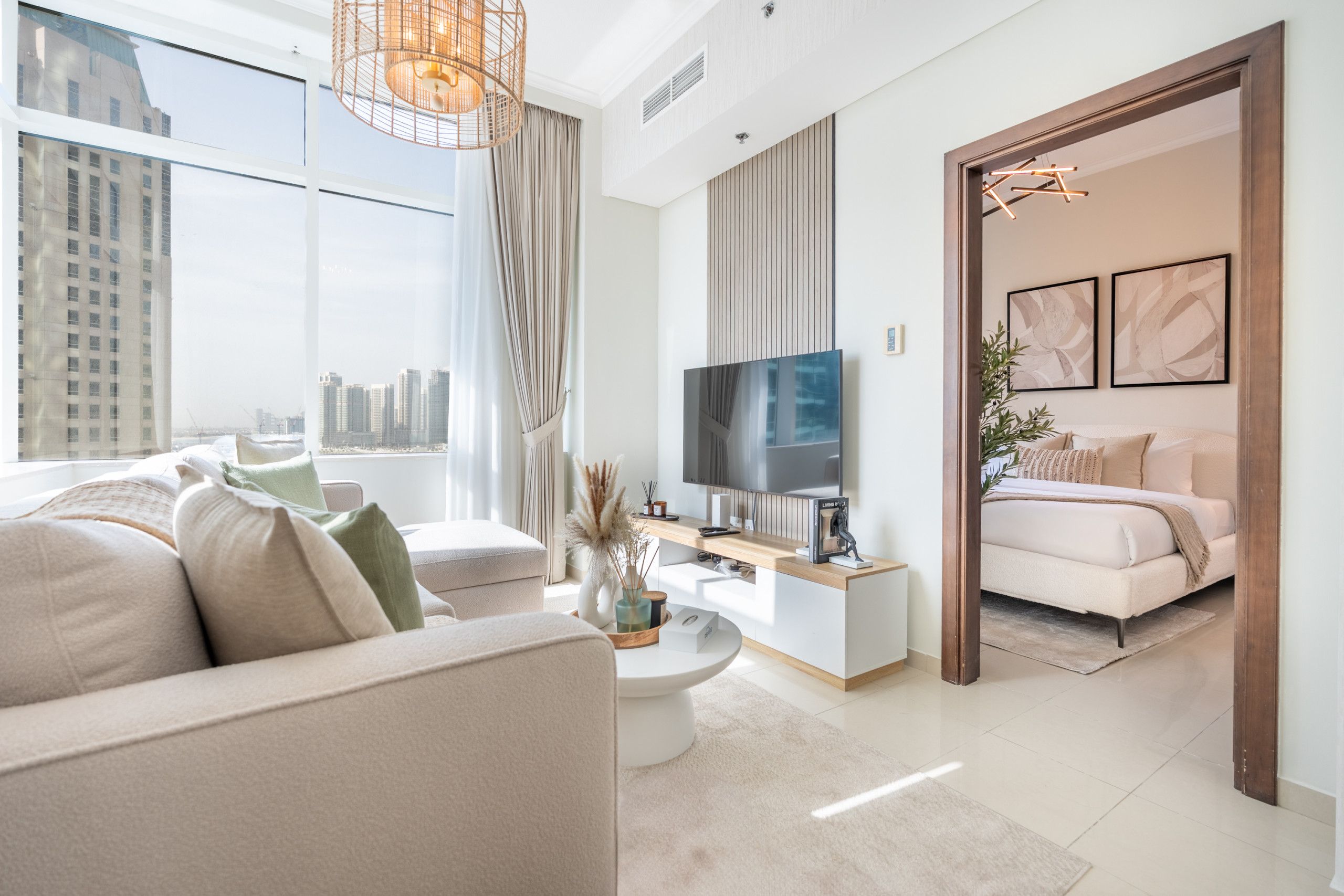 Een moderne woonkamer met een groot raam, een flatscreen televisie, een bank, een salontafel en een bed met houten frame.