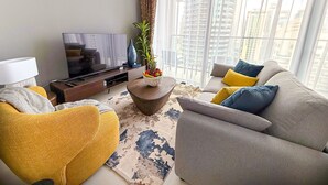 Un salon moderne avec un canapé, un fauteuil et une table basse agrémentée d’une plante.