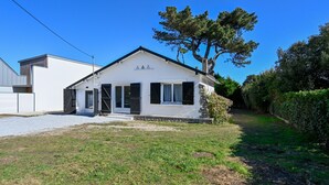 Ein eingeschossiges Haus mit Veranda, Garage und einer kleinen Auffahrt.