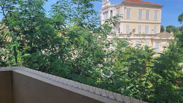 A two-story building with a balcony and a garden in the foreground. - 1 bedroom apartment with balcony near the beach (Saint-Raphaël)