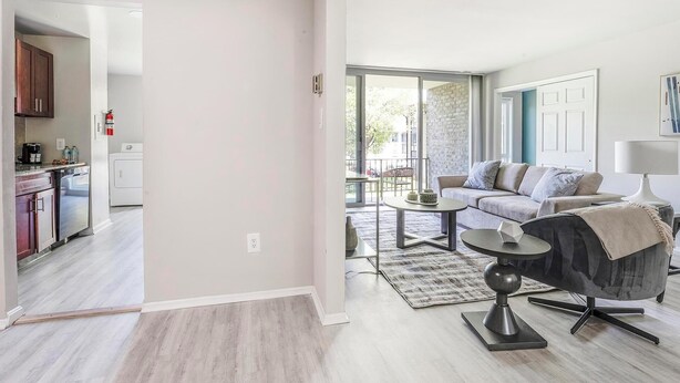 A modern apartment with a kitchen, living area, and balcony.