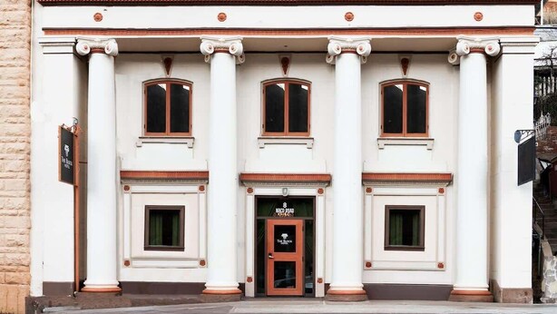A building with three windows and a central entrance with a door. - The Block Basic Room - Queen (Bisbee)