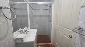 A small bathroom with a shower, a sink, and a toilet. - Comfortable Studio Granny Flat Mermaid Water (Mermaid Waters)