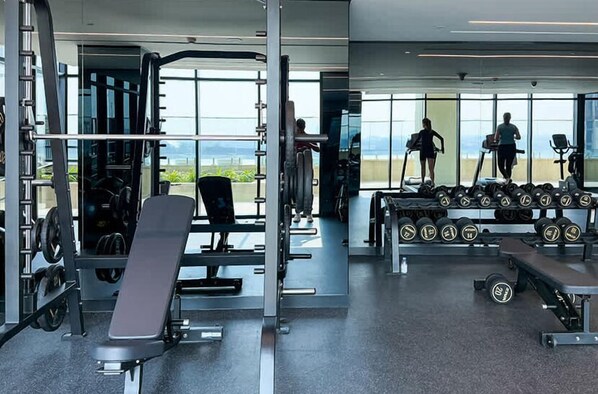 Ein modernes Fitnessstudio mit Kraftgeräten, Laufbändern und Kurzhanteln.