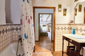 Un baño con bañera, lavamanos y cortina de ducha.