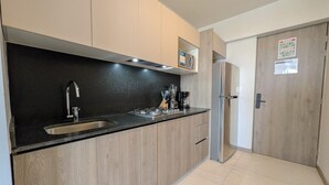Eine moderne Küche mit schwarzem Arbeitsplatz, einer Edelstahl-Spüle und Holzschränken.